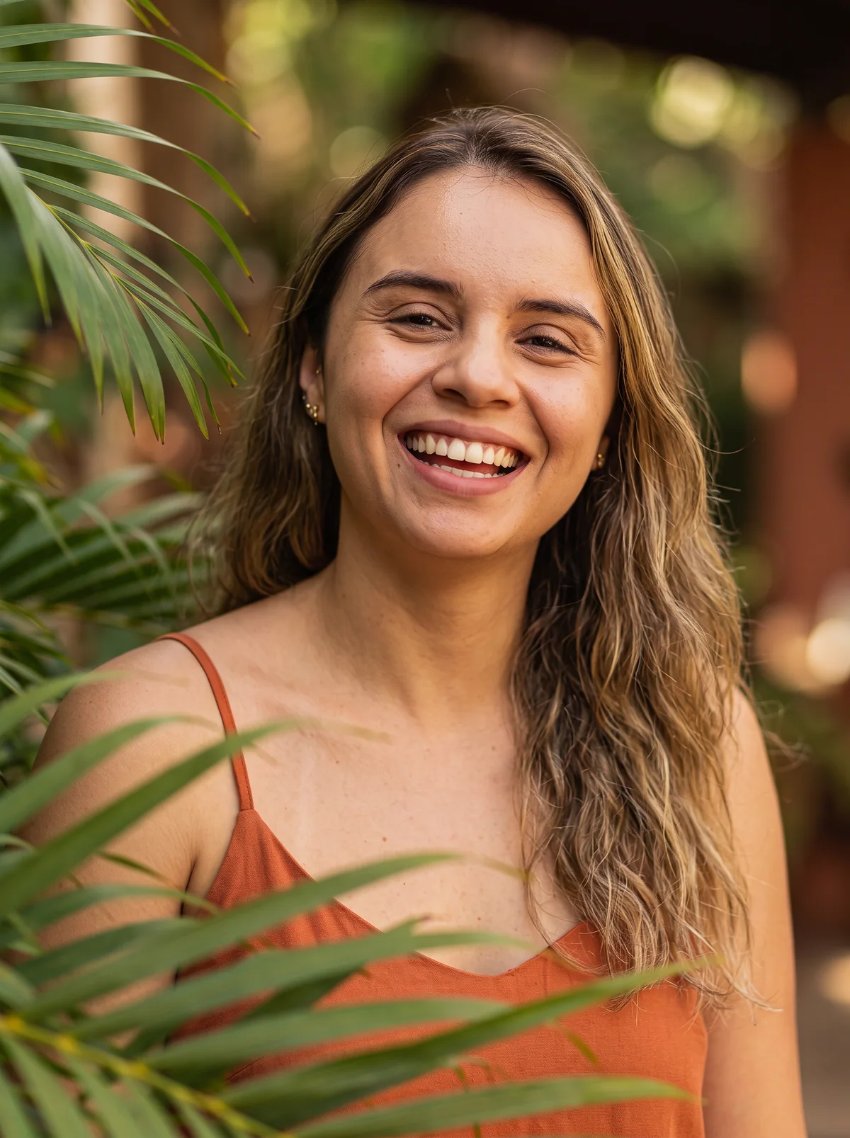 Ana Avilés, arquitecta, sonriendo entre palmas